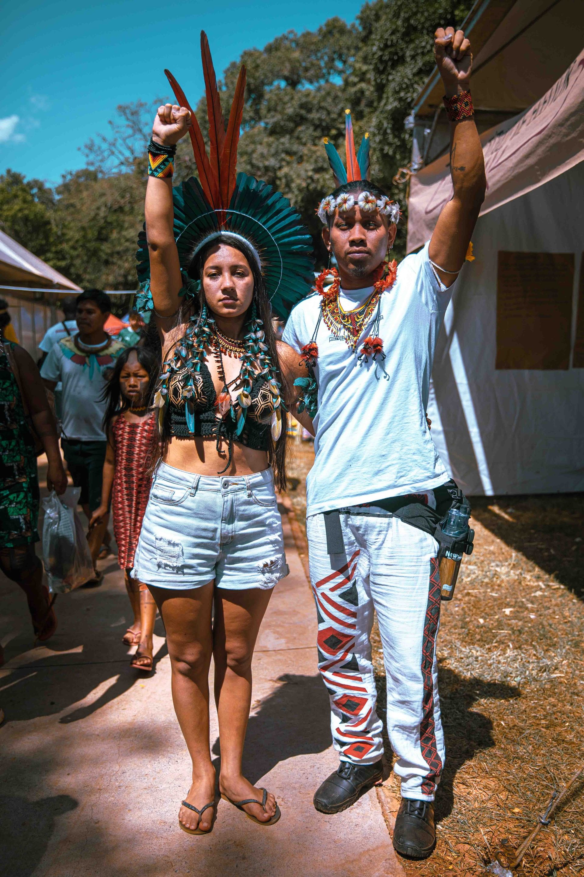 Indigenous activists and social media influencers Samela Sateré-mawe and Tukuma Pataxó raise their fists in solidarity at the Acampamento Terra Livre (ATL) gathering in Brasilia.